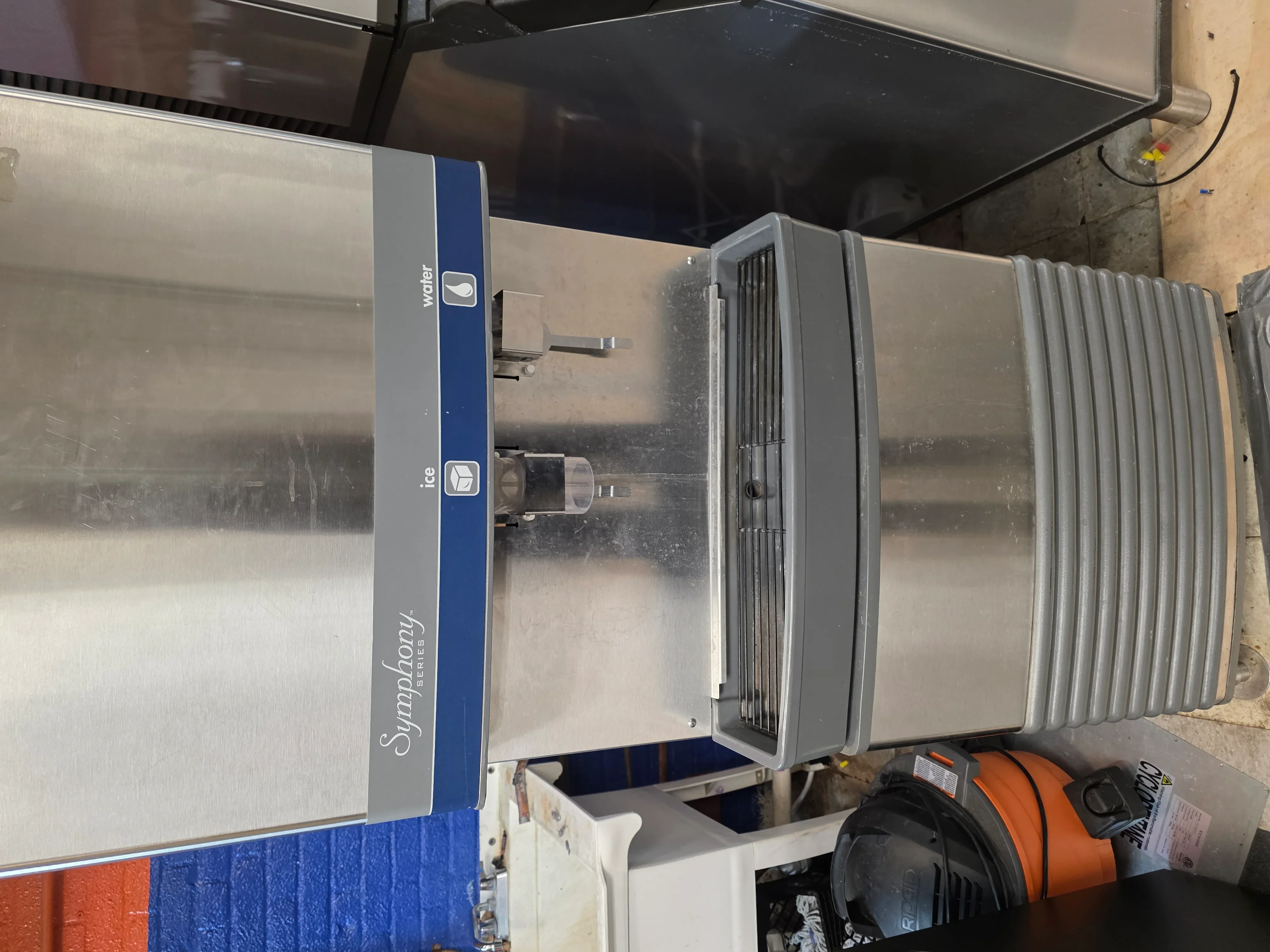 Stainless steel commercial refrigerator with water and ice dispenser installed in commercial kitchen