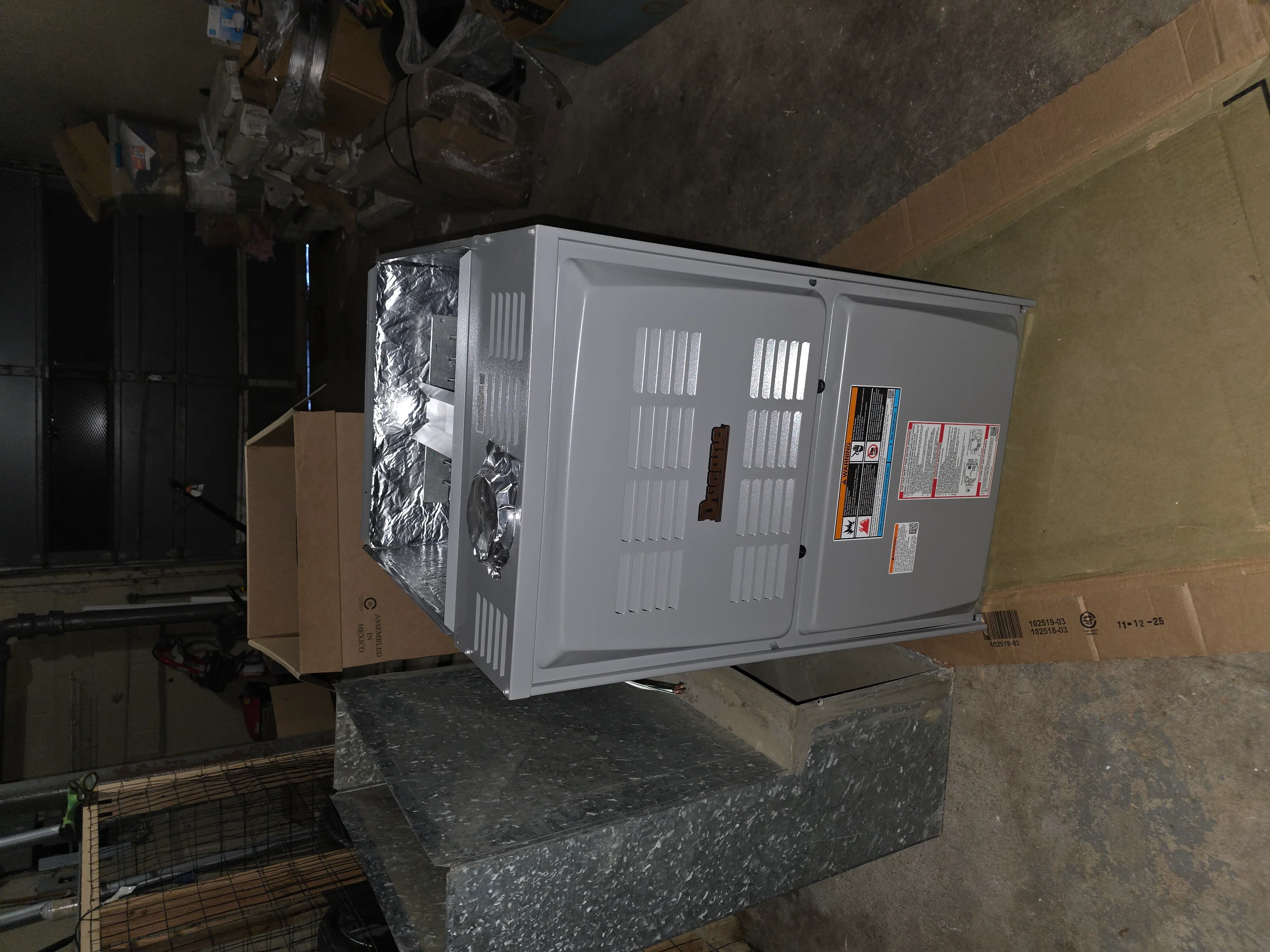 Gray commercial HVAC unit with dual access doors and thermal insulation during installation staging
